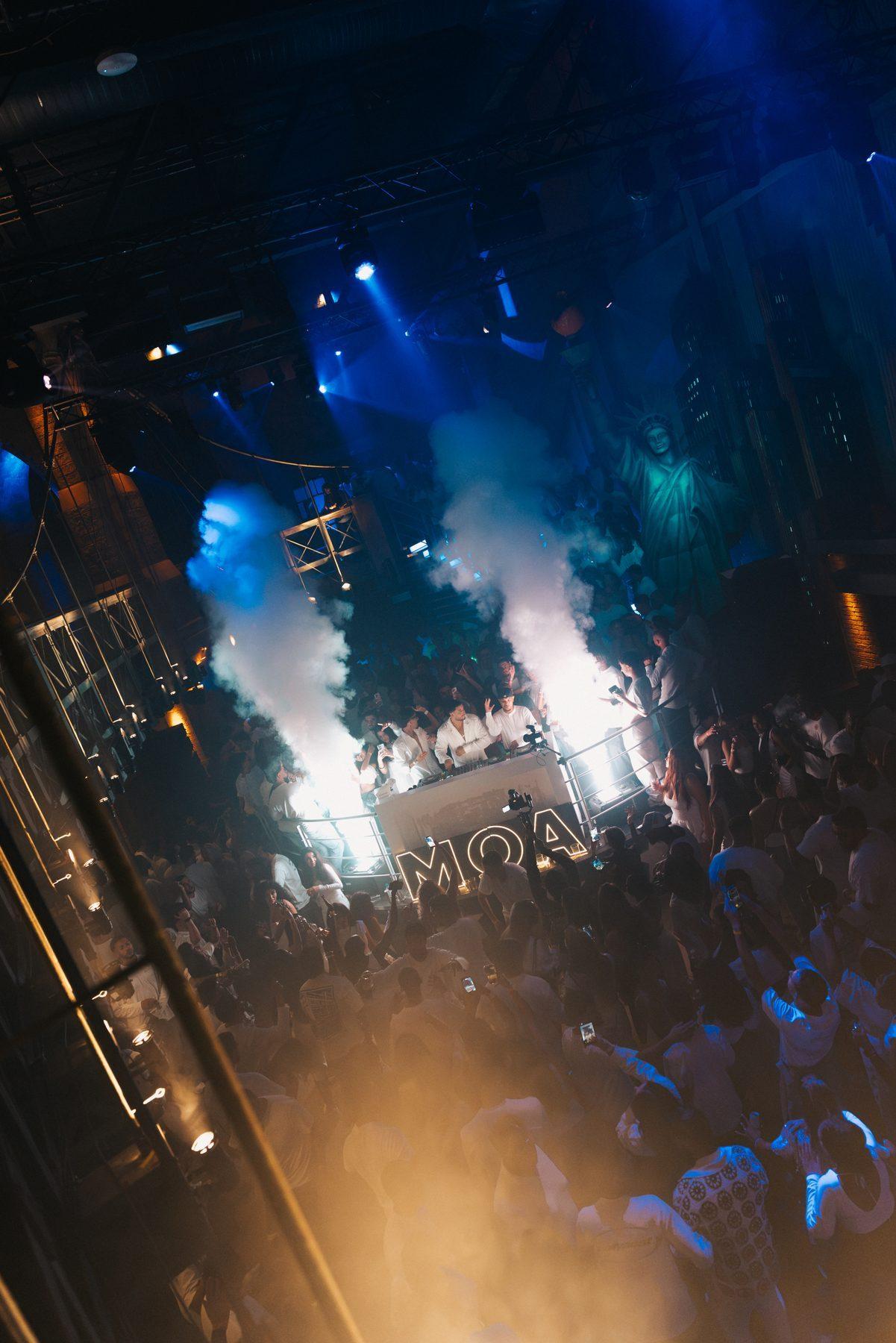 A packed MOA Amsterdam room with the MOA sign in the haze
